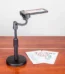 Black plastic phone holder on a three-legged desktop phone tripod standing on a table