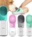White portable dog water bottle with spout held beside a walking dog